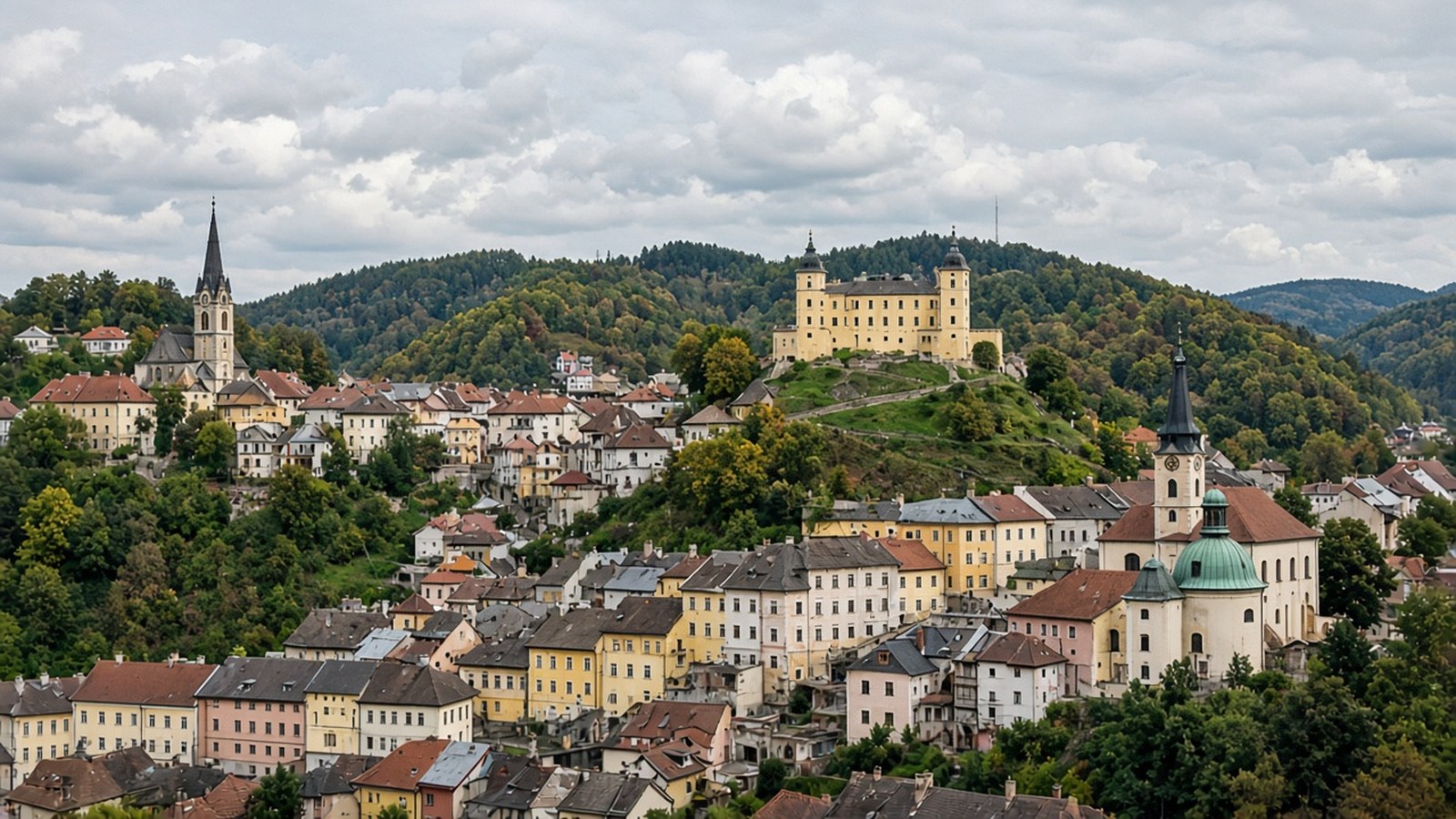 Pohľad na Banskú Štiavnicu s Novým zámkom, kostolmi a meštianskymi domami na svahoch štiavnických vrchov